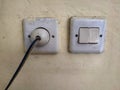 Dirty white switch and plug on the wall. Royalty Free Stock Photo
