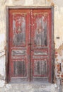 Dirty wooden broken and closed red door in rural old town Royalty Free Stock Photo