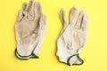 Dirty working gloves on a yellow background