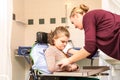 Disability a disabled child in a wheelchair being cared for by a nurse