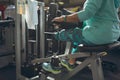 Disabled active senior woman exercising with leg curl machine in fitness studio Royalty Free Stock Photo