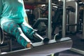 Disabled active senior woman exercising with leg press machine in fitness studio Royalty Free Stock Photo