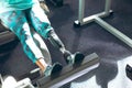 Disabled active senior woman exercising with leg press machine in fitness studio Royalty Free Stock Photo