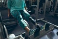 Disabled active senior woman exercising with leg press machine in fitness studio Royalty Free Stock Photo