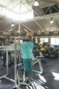 Disabled active senior woman exercising with squat machine in fitness studio Royalty Free Stock Photo