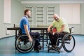 Disabled adult men laughing after playing table tennis