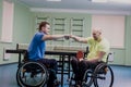Disabled adult men shaking hands after playing table tennis