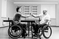 Disabled adult men shaking hands after playing table tennis