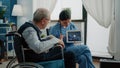 Disabled aged man looking at virus animation on tablet Royalty Free Stock Photo