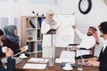 Disabled arab man in wheelchair working in office. Man and female coworker are doing presentaion. Royalty Free Stock Photo