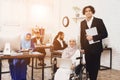 Disabled arab woman in wheelchair working in office. Woman is posing with male coworker.