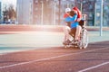 Disabled athlete in a wheelchair on an athletics track. Son hugs his father.