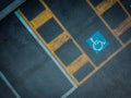 Disabled blue parking sign painted on dark asphalt. Empty handicapped spaces on black Royalty Free Stock Photo