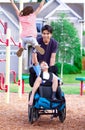 Disabled boy in wheelchair enjoying watching friends play at par Royalty Free Stock Photo