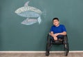 Disabled boy on wheelchair showing his painting on wall with happy and proud. Idea for learning ability of handicapped kid Royalty Free Stock Photo