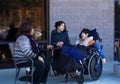Disabled boy in wheelchair at table outdoors talking with caregivers Royalty Free Stock Photo