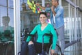 Disabled businesswoman looking at camera while male executive writing on sticky notes Royalty Free Stock Photo