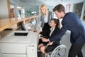 Disabled businesswoman in wheelchair and colleague in office Royalty Free Stock Photo