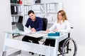 Disabled businesswoman in wheelchair and her colleague Royalty Free Stock Photo