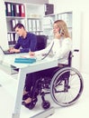 Disabled businesswoman in wheelchair and her colleague Royalty Free Stock Photo