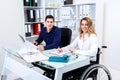 Disabled businesswoman in wheelchair and her colleague Royalty Free Stock Photo