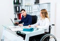 Disabled businesswoman in wheelchair and her colleague Royalty Free Stock Photo