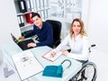 Disabled businesswoman in wheelchair and her colleague Royalty Free Stock Photo