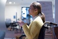 Disabled businesswoman in the wheelchair using her laptop while performing in co-working space. Disability and handicap concept. Royalty Free Stock Photo