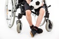 Disabled child boy sitting on wheelchair holding soccer ball