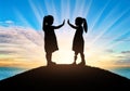 Disabled child girl with prosthetic legs and her friend outdoors at sunset near the sea Royalty Free Stock Photo