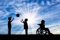 Disabled child in wheelchair crying near children play with ball