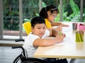 A disabled child in a wheelchair and a cute little girl with down syndrome Royalty Free Stock Photo