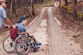 Disabled child on wheelchair is playing learning and exercise in the outdoor like other people with parent Forest background 