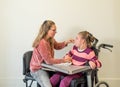 A disabled child in a wheelchair together with a voluntary care worker Royalty Free Stock Photo