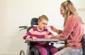 A disabled child in a wheelchair together with a voluntary care worker Royalty Free Stock Photo