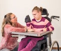 A disabled child in a wheelchair together with a voluntary care worker Royalty Free Stock Photo