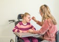 A disabled child in a wheelchair together with a voluntary care worker