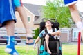 Disabled child in wheelchair watching children play at park Royalty Free Stock Photo