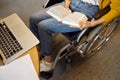 Disabled female student holds a book, top view