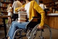 Disabled female student holds stack of books