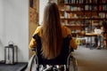 Disabled female student in wheelchair, back view