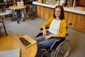 Disabled female student in wheelchair using laptop