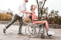 Disabled girl feeling special while boyfriend pushing her wheelchair