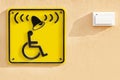 Disabled help call button. yellow plate with the image of a disabled person and a call button