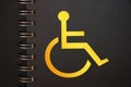 Disabled icon yellow in black copybook. Disabled people equal rights diversity program concept