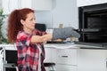 Disabled independant woman in wheelchair preparing meal in kitchen Royalty Free Stock Photo