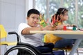 Disabled kids classroom, children having fun during study at school, kids learning together, schoolboy on wheelchair showing his Royalty Free Stock Photo