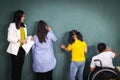 Disabled kids classroom, school boy on wheelchair and down syndrome girls learning and having fun during study at school with Royalty Free Stock Photo