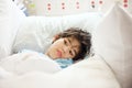 Disabled little boy lying sick in hospital bed Royalty Free Stock Photo