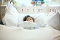 Disabled little boy lying sick in hospital bed Royalty Free Stock Photo